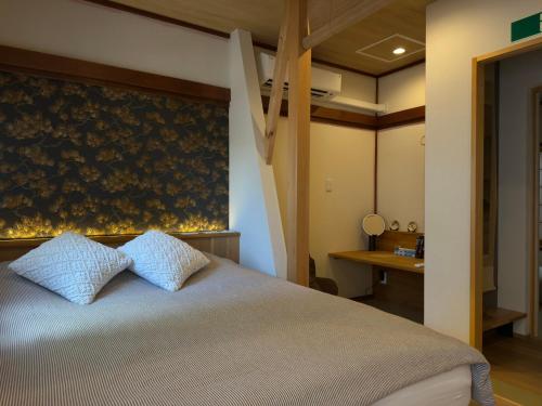 une chambre avec un lit avec deux oreillers bleus dans l'établissement 京都 三日月 Mikazuki, à Kyoto