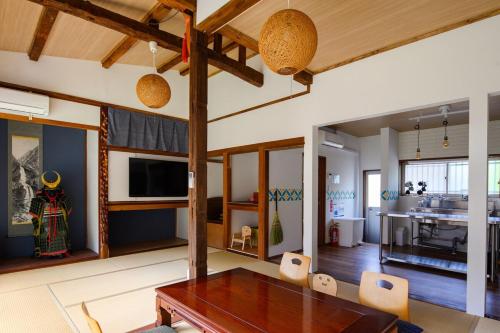 a living room with a wooden table and chairs at Guest House DAN 団 in Yokohama