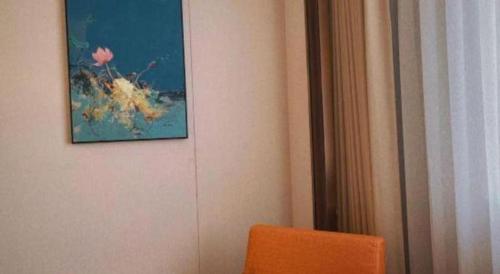 a painting hanging on a wall next to a chair at Chaozhou Hotel in Chaozhou