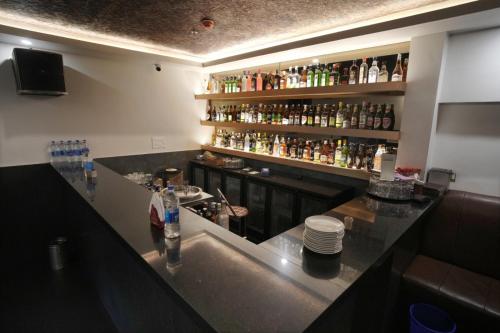 a bar with a counter with a lot of bottles of alcohol at Alleppey Prince Hotel in Alleppey