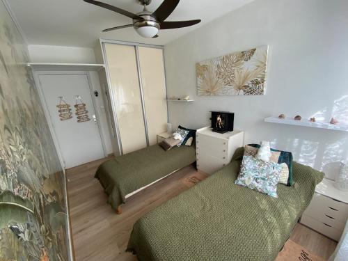 Cette chambre comprend deux lits et un ventilateur de plafond. dans l'établissement Le Cosy Corse, à Vico