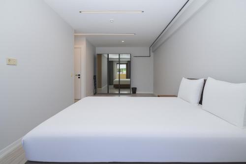 a white bedroom with a large white bed at Sia Hotel Thermal & Spa in Nilüfer