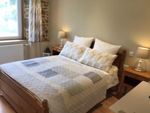 une chambre avec un grand lit avec deux tables de nuit dans l'établissement Cherry Tree Avenue, à Le Ferré