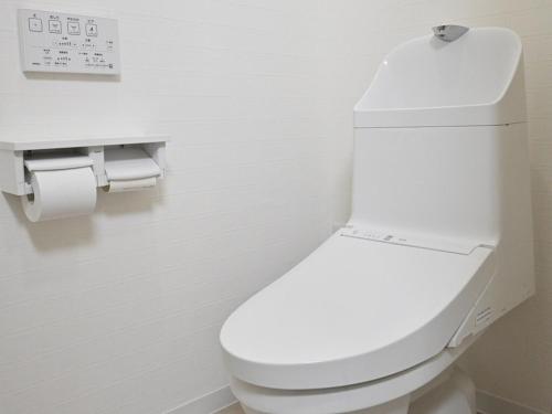 a bathroom with a white toilet in a room at ｹﾞｽﾄﾊｳｽ ﾊﾞｲｸﾔﾉﾆｶｲ in Hagi