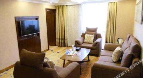 a living room with two couches and a television at Liyuan Hotel in Shenzhen