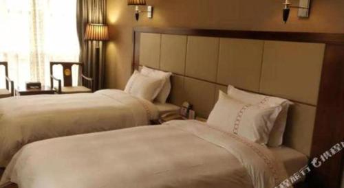 a hotel room with two beds with white sheets at Liyuan Hotel in Shenzhen