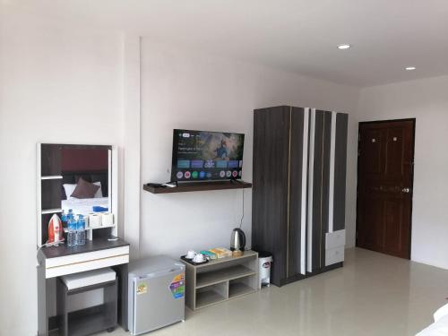 a kitchen with a refrigerator and a tv on the wall at Patong Beach Dream House in Patong Beach
