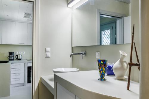 a white kitchen with a sink and a vase on a counter at Iremia Coastal Retreat in Neo Klima