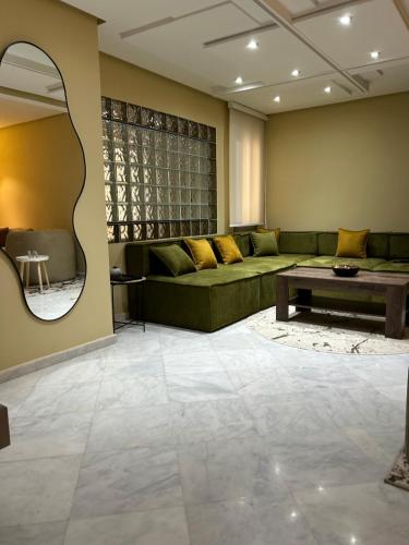 a living room with a green couch and a mirror at Sofia 1 Tanger #Castilla in Tangier