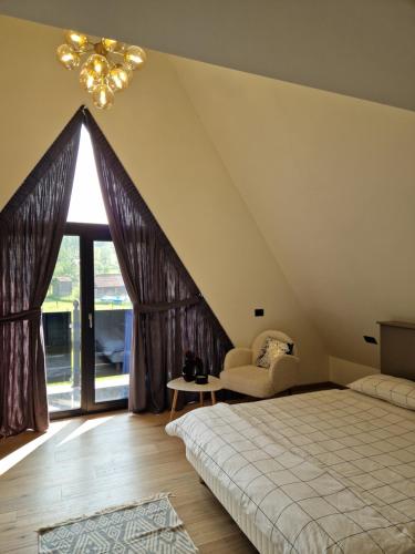 a attic bedroom with a bed and a window at Vila Timeea in Statiunea Borsa