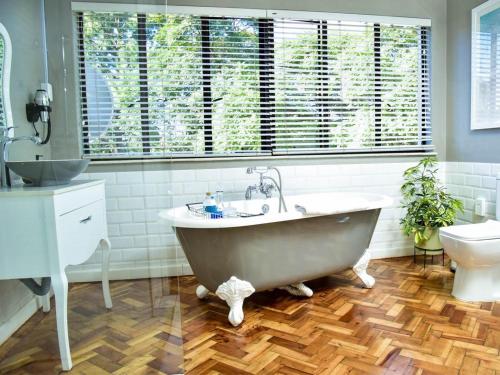 a bathroom with a large tub and a toilet at C'est La Vie Boutique Hotel in Witbank