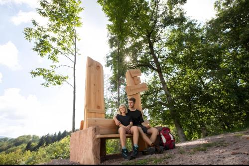 a man and a woman sitting on a bench at Ferienwohnung Schöner in Oberharmersbach