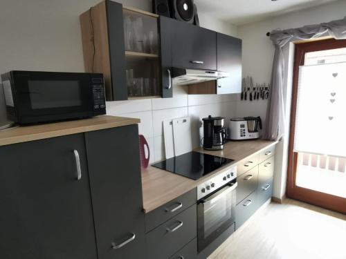 a kitchen with a microwave and a stove top oven at Ferienwohnung Schöner in Oberharmersbach