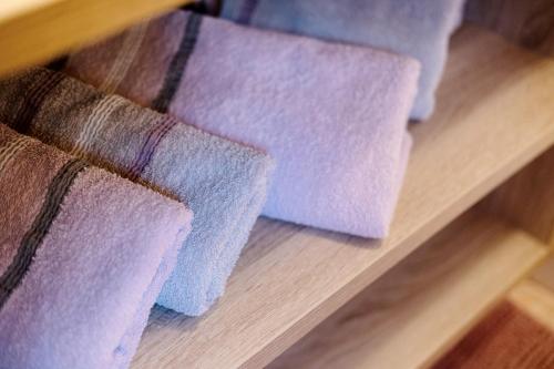 three purple towels sitting on a wooden shelf at Ausser Brugghof in Senales
