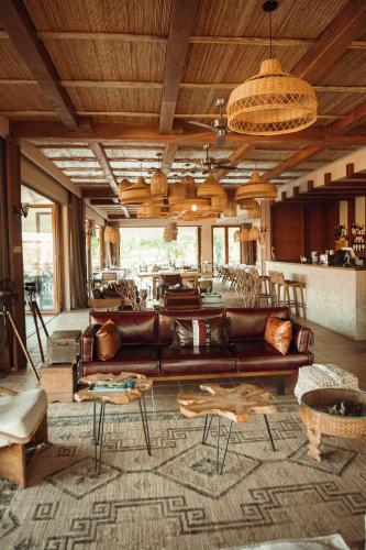 a living room with a leather couch and a table at Entikko Safari Lodge in Fajao