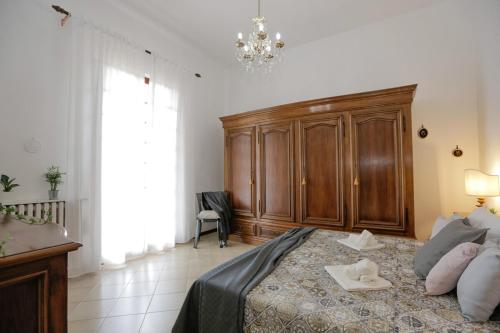 a bedroom with a large bed and a chandelier at Spazioso appartamento con Giardino a Parcheggio Gratuito in Massa