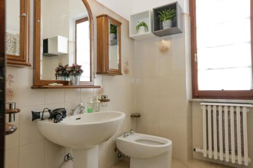 a bathroom with a sink and a toilet at Spazioso appartamento con Giardino a Parcheggio Gratuito in Massa