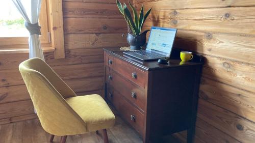 a laptop computer sitting on top of a dresser with a chair at Litewska Chata 