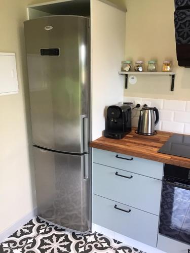 une cuisine avec un réfrigérateur en acier inoxydable dans l'établissement Cherry Tree Avenue, à Le Ferré