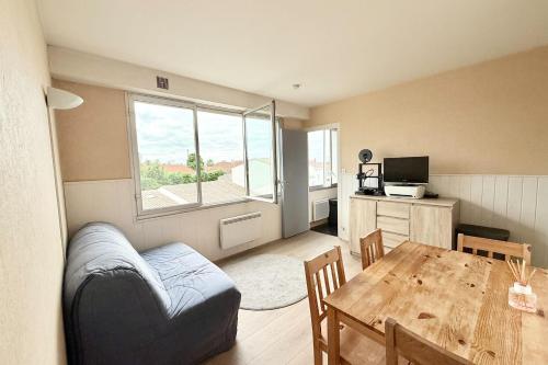 un salon avec une table et un canapé dans l'établissement Bright apartment for 4 people, à La Rochelle