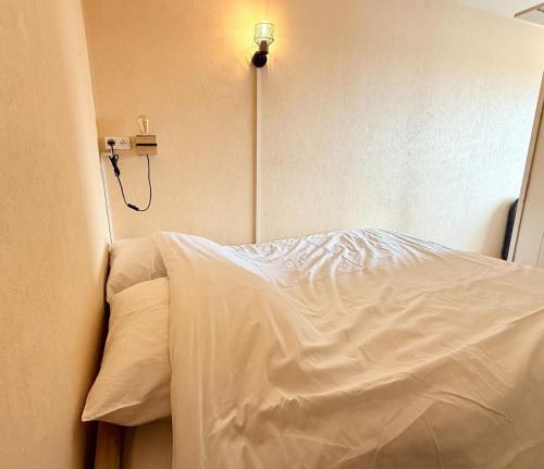- une chambre dotée d'un lit blanc avec une lumière sur le mur dans l'établissement Bright apartment for 4 people, à La Rochelle