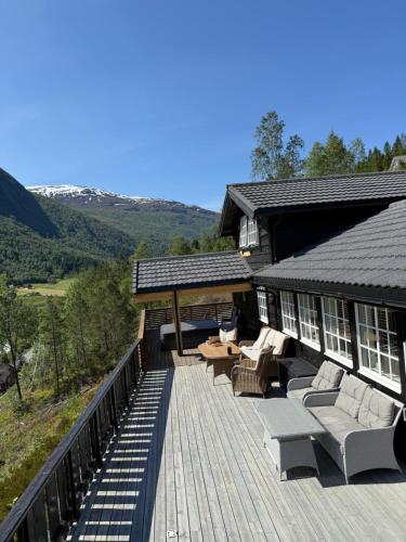 a wooden deck with couches and chairs on a house at Tenna 48 in Stryn