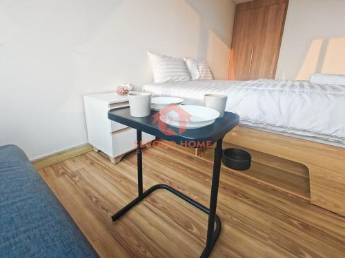 a blue table in a room with a bed and a bedroom at Cozy Studio South Gate Apt with Pool, Gym, Wi-Fi by 2ndHome in Jakarta