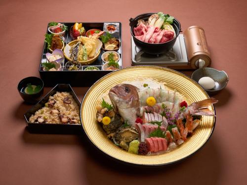 a table with a plate of food and a tray of food at 瀬戸内ゴルフリゾートヴィラ in Takekara