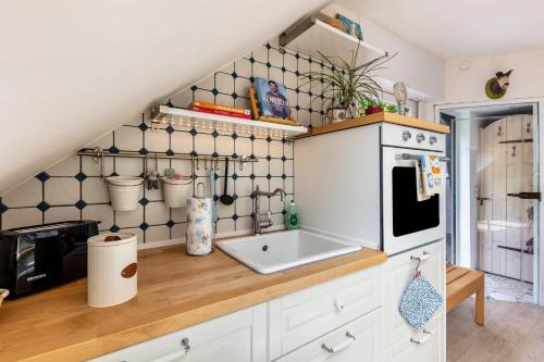 a kitchen with white cabinets and a sink at Ferienwohnung Am Jakobsweg in Schmallenberg