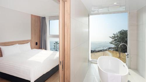 a bedroom with a bed and a large window at PANAQ operated by SONO in Yeongdeok
