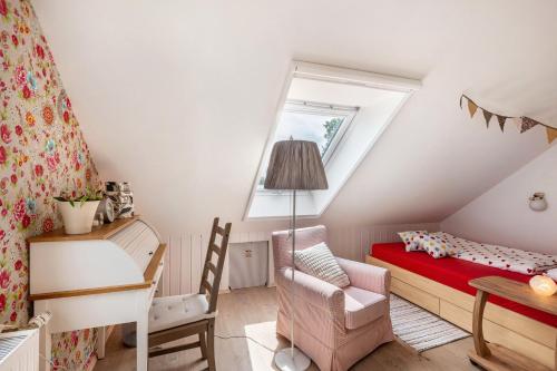 a small attic bedroom with a bed and a desk at Ferienwohnung Am Jakobsweg in Schmallenberg