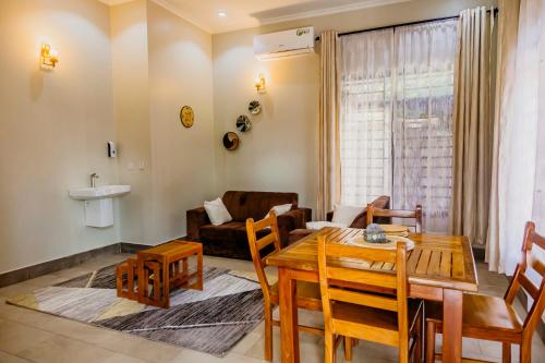 a living room with a table and chairs and a couch at Dodo homes in Uru