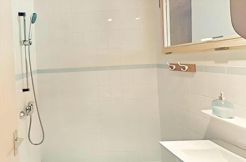 a white bathroom with a shower and a sink at CASA-Lodge Lili pour 2 personnes in Molines-en-Queyras