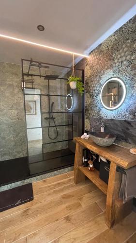 une salle de bain avec un lavabo et un miroir dans l'établissement Olaris - Appartement 2 chambres - Terrasse privée & Piscine partagée, à Bras
