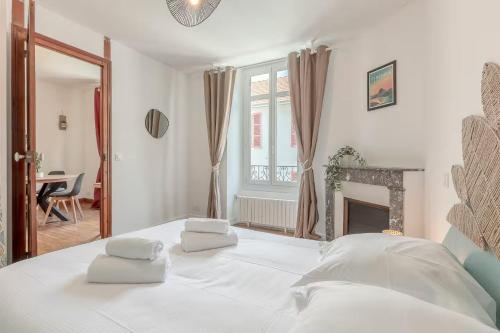 un lit blanc avec deux serviettes dessus dans l'établissement L'Anglais,Charmant T2,Pour 4 adultes et 1 enfants, à Pau