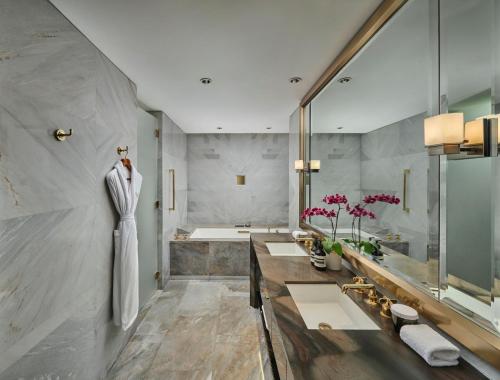 a bathroom with three sinks and a bath tub at Waldorf Astoria Beijing in Beijing