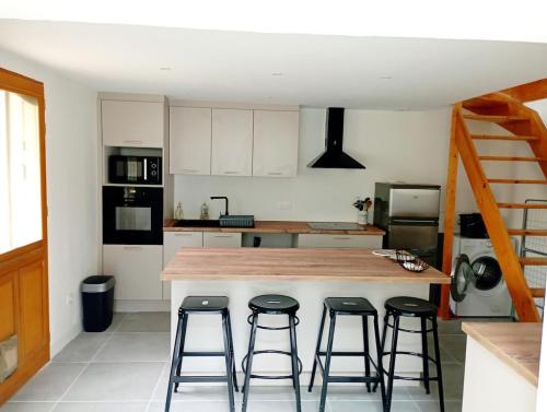 d'une cuisine avec un comptoir avec quatre tabourets. dans l'établissement La maisonnette cachée de Dampmart, à Dampmart