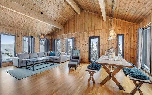 a living room with a couch and a table at Gaustatoppen Hytteutleie in Gaustablikk