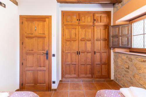 two wooden doors in a room with a counter at Finca La Lobera in Candeleda