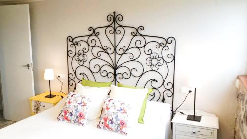 a bed with a black iron headboard and pillows at Bungalow MAR Y MONTAÑA in Laredo