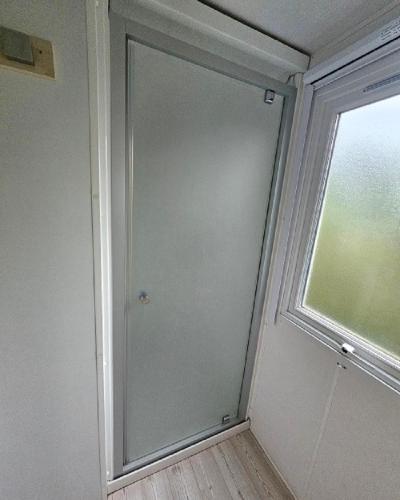 a glass door in a room with a window at Camping de Charlieu in Charlieu