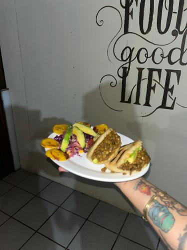 a person holding a plate with food on it at fenix soul hostel ocean view in Drake