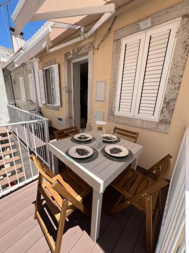 a white table with chairs on a balcony at Blue Bay Beach Apartment - Maria in Sesimbra