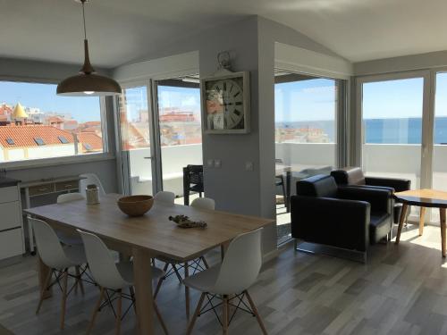 a kitchen and living room with a table and chairs at Blue Bay Beach Apartment in Sesimbra