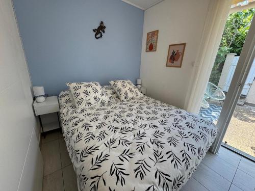 une chambre avec un lit avec une couette noire et blanche dans l'établissement Terrasse de la bergerie, 4 personnes avec piscines, au Cap d'Agde