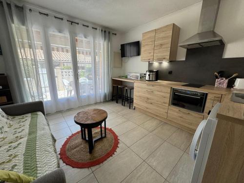 - une cuisine avec une table au milieu d'une pièce dans l'établissement Terrasse de la bergerie, 4 personnes avec piscines, au Cap d'Agde