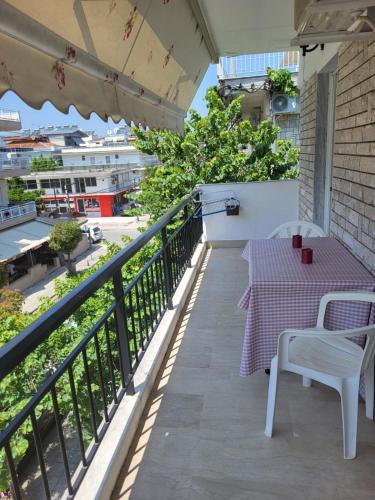 a patio with a table and chairs on a balcony at Queen's apartment in Olympiaki Akti