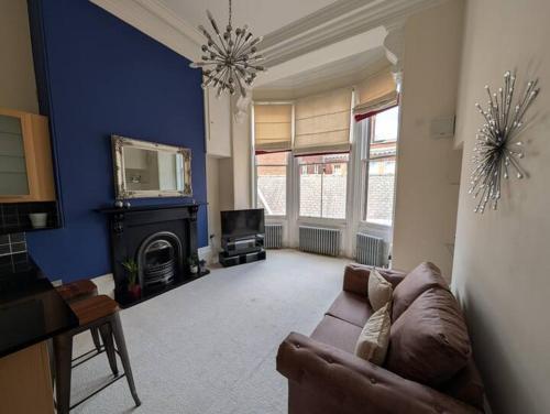 a living room with a brown couch and a tv at Charming Old Town Apartment in Hull