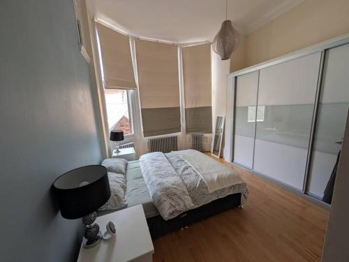 a bedroom with a bed and a large window at Charming Old Town Apartment in Hull