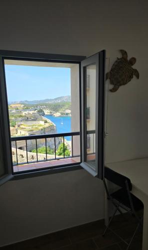 Cette chambre dispose d'une fenêtre offrant une vue sur l'océan. dans l'établissement Bonifacio Appartement charme vieille ville, à Bonifacio